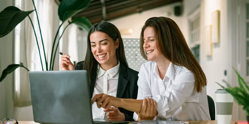 Två kvinnor, kollegor sitter vid en dator och ser mycket koncentrerade ut, problemlösning på jobbet Akavia Aspekt
