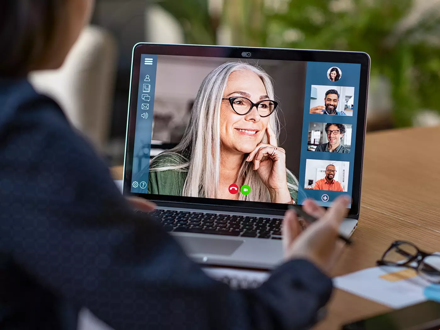 Ett arbetsmöte sker via digitalt forum på dator, flera medarbetare deltar. De diskuterar och ser glada ut tillsammans.
