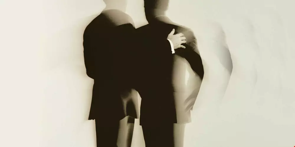 En svart-vit bild personer med ryggen mot kameran, en tydlig person med armen runt en eller flera personer som flyter ut mot fjärran suggestiv illustration av anklagelse Akavia Aspekt