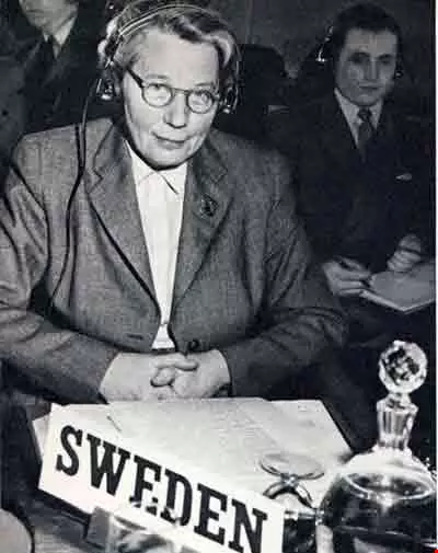 Gammal bild av äldre kvinna i kostym med glasögon i svartvitt