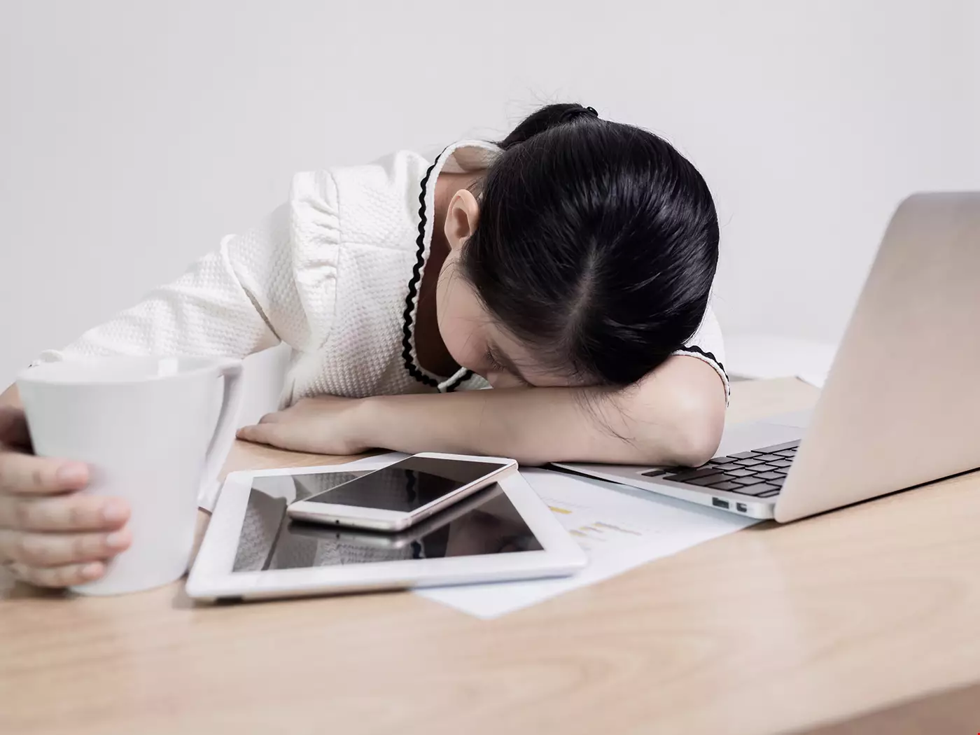 Kvinna sover med huvudet på skrivbord