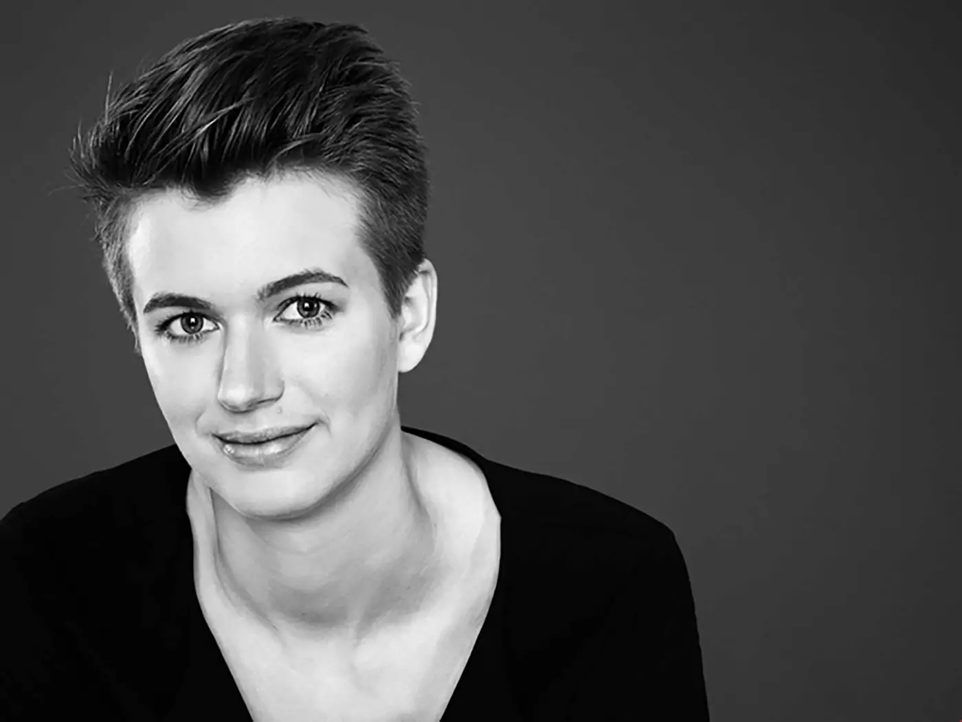 Ung kvinna i kortklippt frisyr. Svarvit bild. 